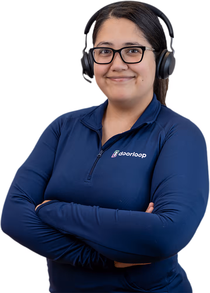 Smiling woman wearing glasses, a headset, and a navy blue DoorLoop zip-up shirt with arms crossed.
